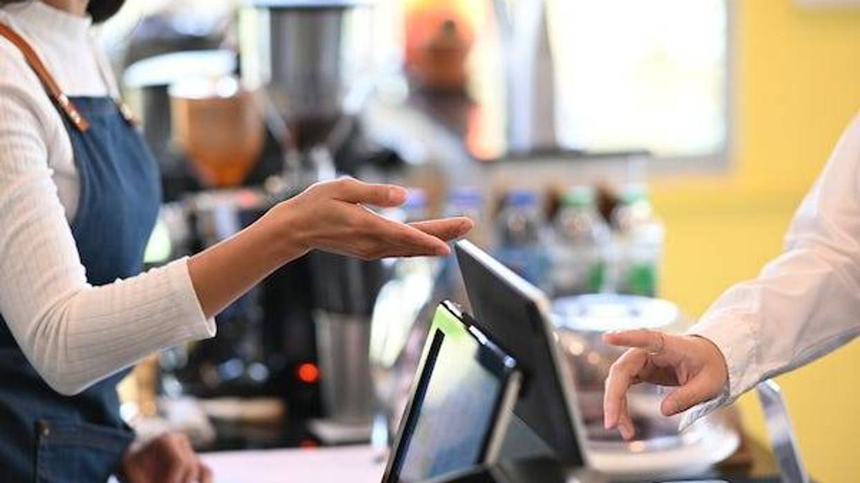 Barista pointing to counter tablet for customer