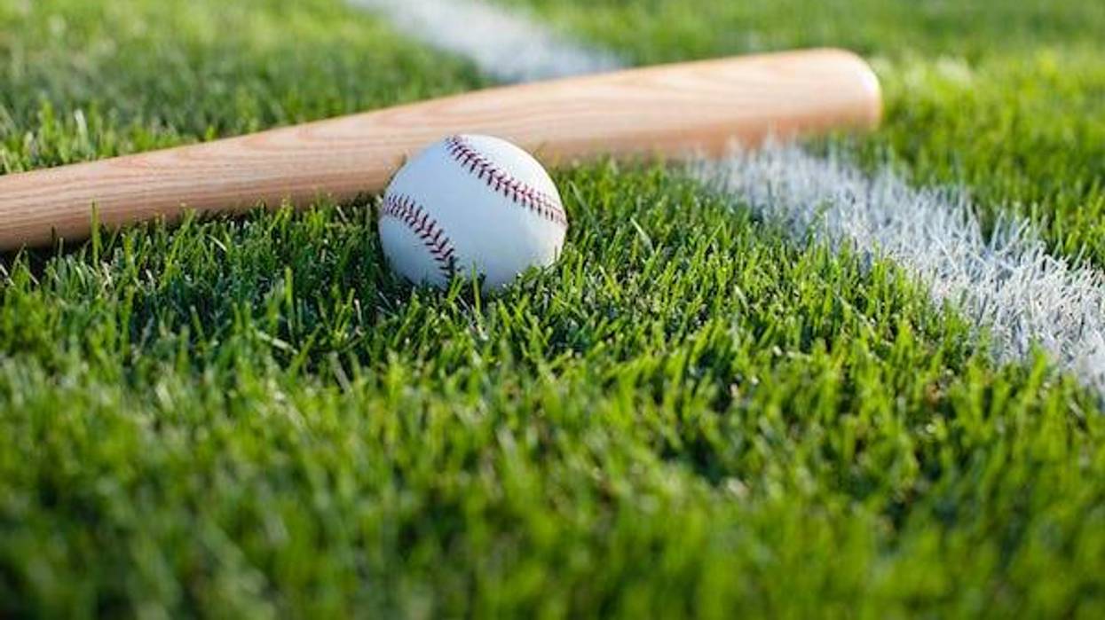Baseball and bat on grass field with white stripe