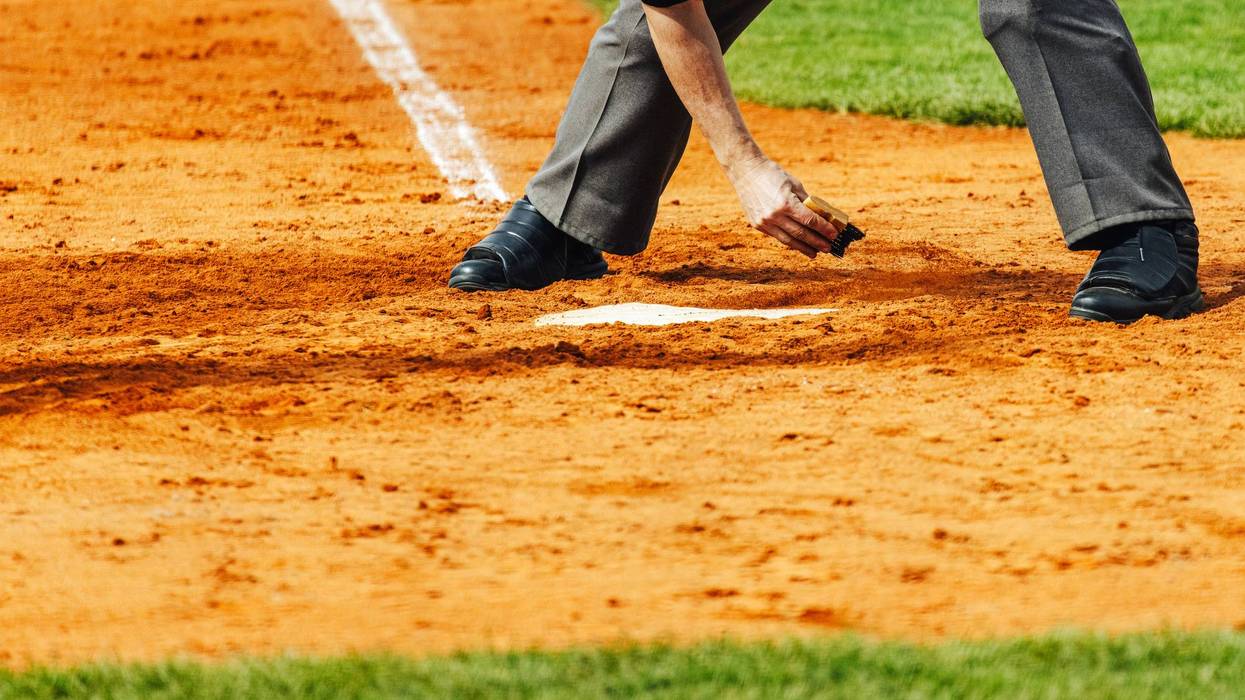 Baseball, umpire clears home plate, close up view, summer team sports