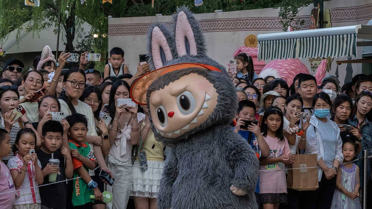 BEIJING, CHINA - JULY 17: A performer wears a costume of a character from Pop Mart's hugely popular Labubu dolls series while dancing for visitors at the Pop Land theme park on July 17, 2025 in Beijing, China. The viral 'monster' dolls are so popular that Pop Mart, the Beijing-based company behind the craze, saw its profits soar by 350% in the first half of the year. The obsession with Labubu, furry creatures with pointy ears and exactly nine teeth, have inspired long lineups and occasional tussles in some countries as well as a growing black market for imposter products seeking to cash in. Labubu dolls, created by Hong Kong artist Kasing Lung, first debuted in 2019 but hit global status more recently when they became the accessory toy of choice for celebrities including Rihanna, Dua Lipa, and Blackpink's Lisa. A key part of Pop Mart's commercial success with Labubu is so-called 'blind boxes' where customers find out what they buy only when they open the package. (Photo by Kevin Frayer/Getty Images)