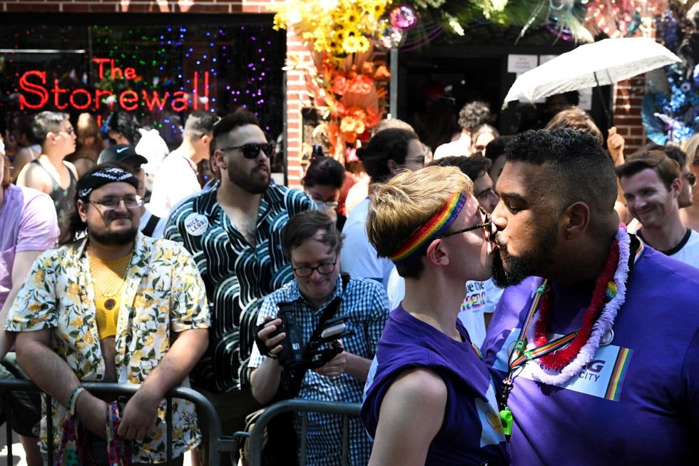 Ben Eisenstadt from New York and Paul Staisiunas from New York kiss for photographers in front of the Stonewall Inn the New York City Pride Parade on June 26, 2022 in New York City.