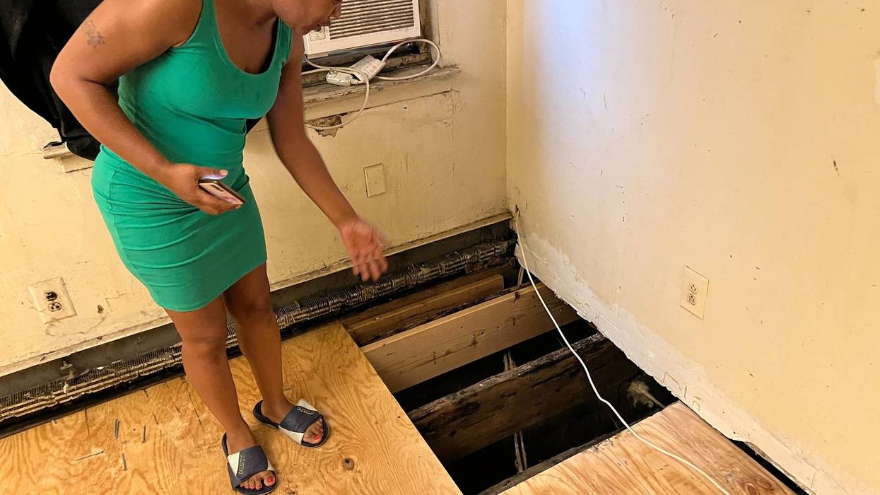 Betzaida Kellum shows the hole in her bedroom floor where mold had been growing.