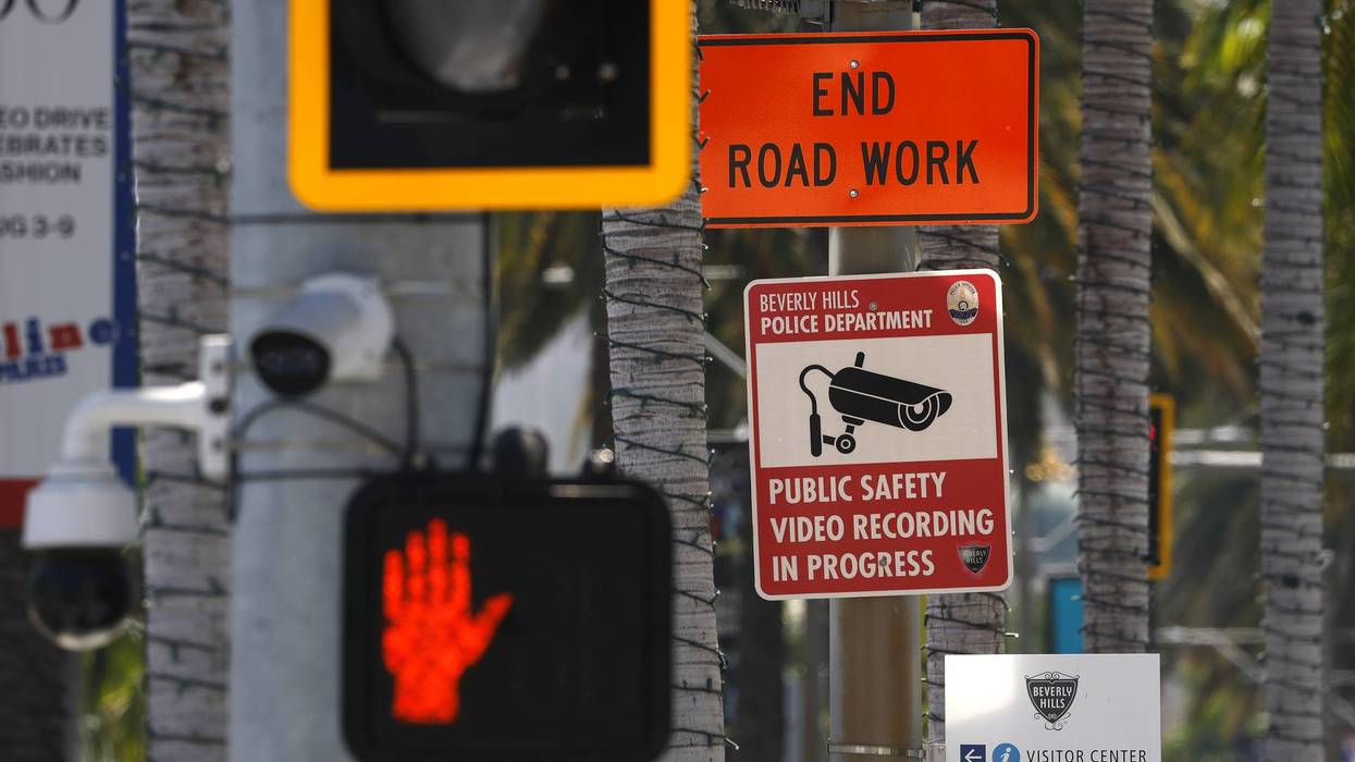 Beverly Hills street with signs for "End Road Work", "Video Recording In Progress", cameras, and red hand.