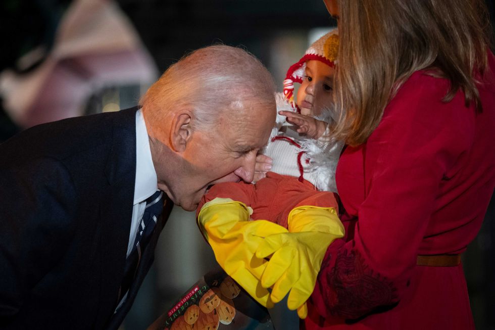 Biden jokingly bites the leg of a baby