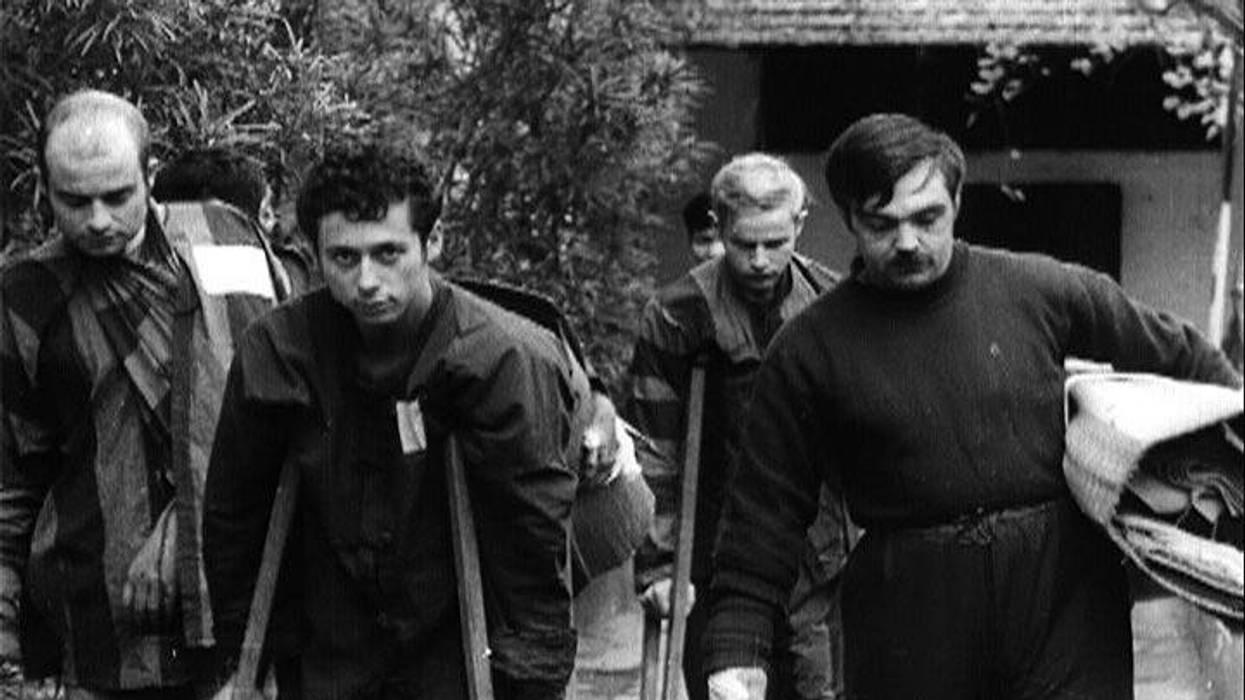 Bill Arcuri on crutches, front middle taken while a POW