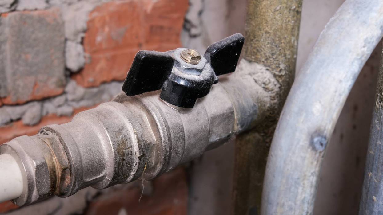 Black brass ball shut-off valves on water supply pipeline in the house, plumbing and construction concept