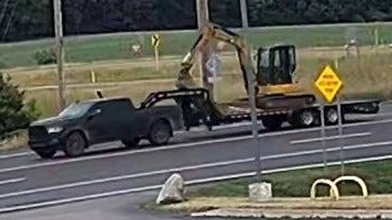 Black Dodge Ram hauling stolen mini-excavator way from construction site