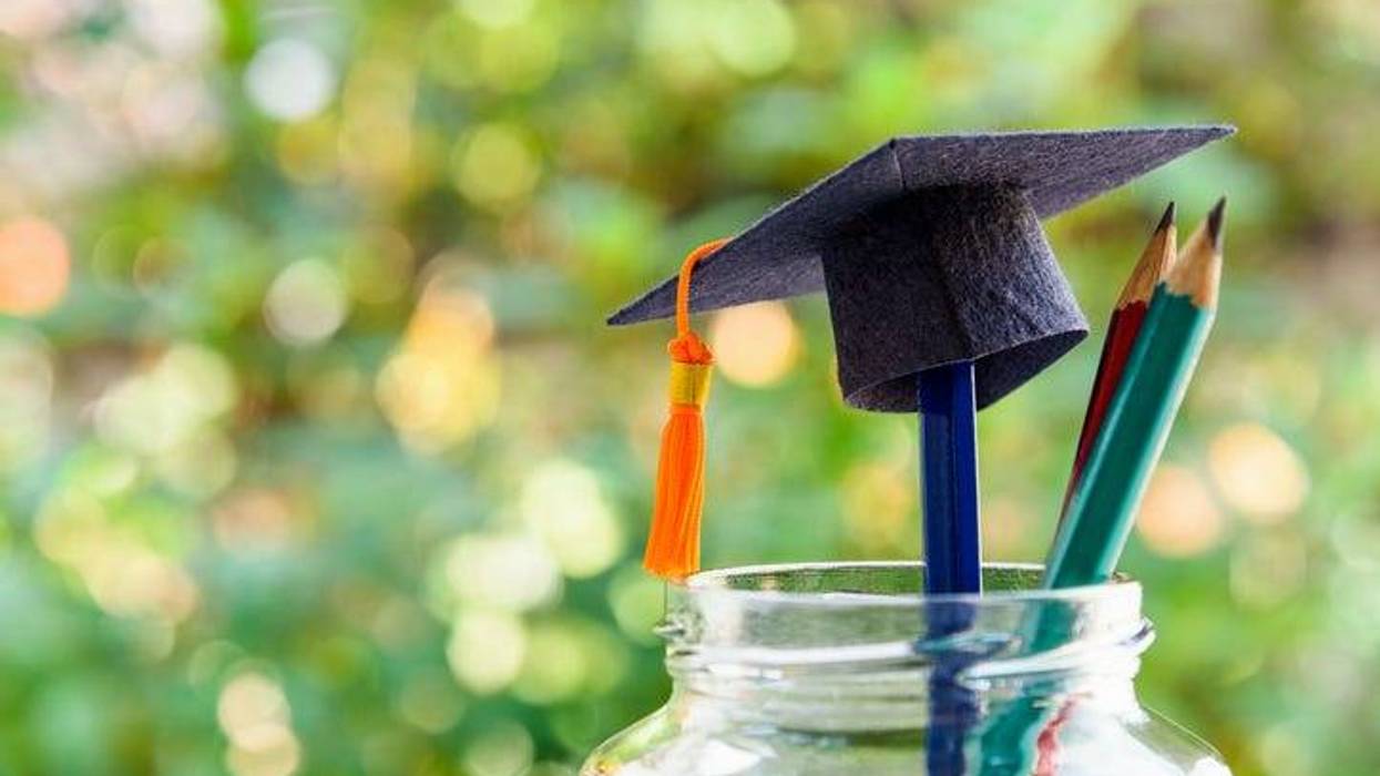 Black graduation cap and a pencil in a mason jar