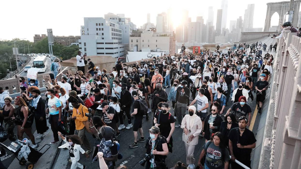 Black Lives Matter supporters and others march across the Brooklyn Bridge to honor George Floyd on the one year anniversary of his death on May 25, 2021 in New York City