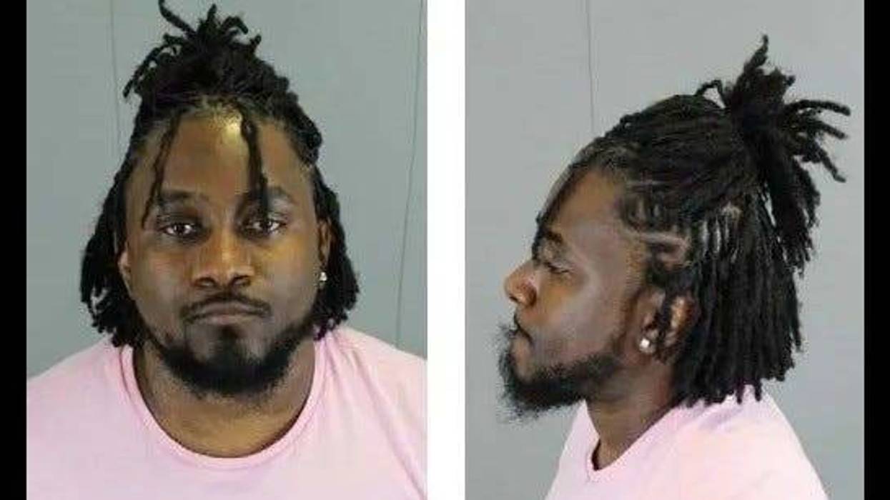 Black man in 30s wearing pink shirt with beard