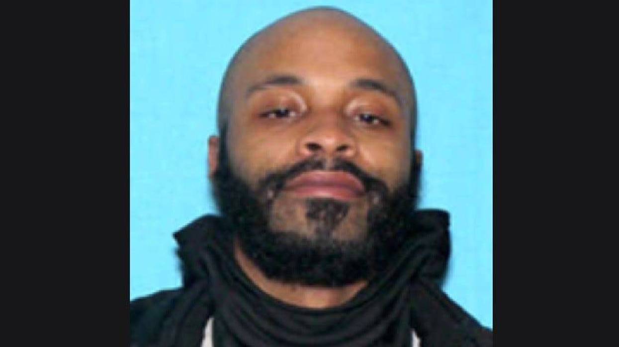 Black man in his 20s with black beard and bald head