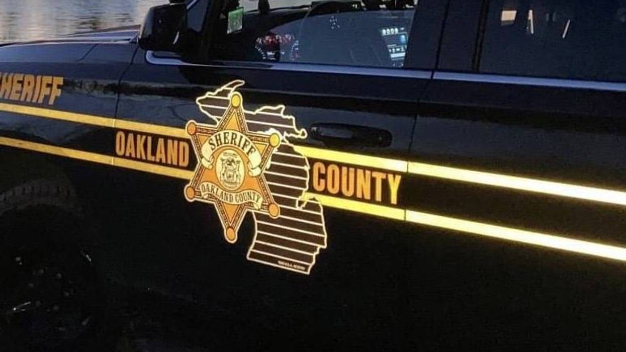 Black Oakland County Sheriff vehicle with yellow text, badge, and Michigan outline on the side.