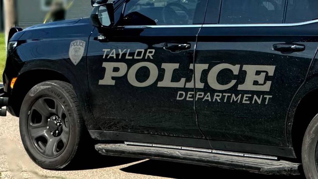 Black Taylor Police Department vehicle with 'POLICE DEPARTMENT' lettering and badge on the side.