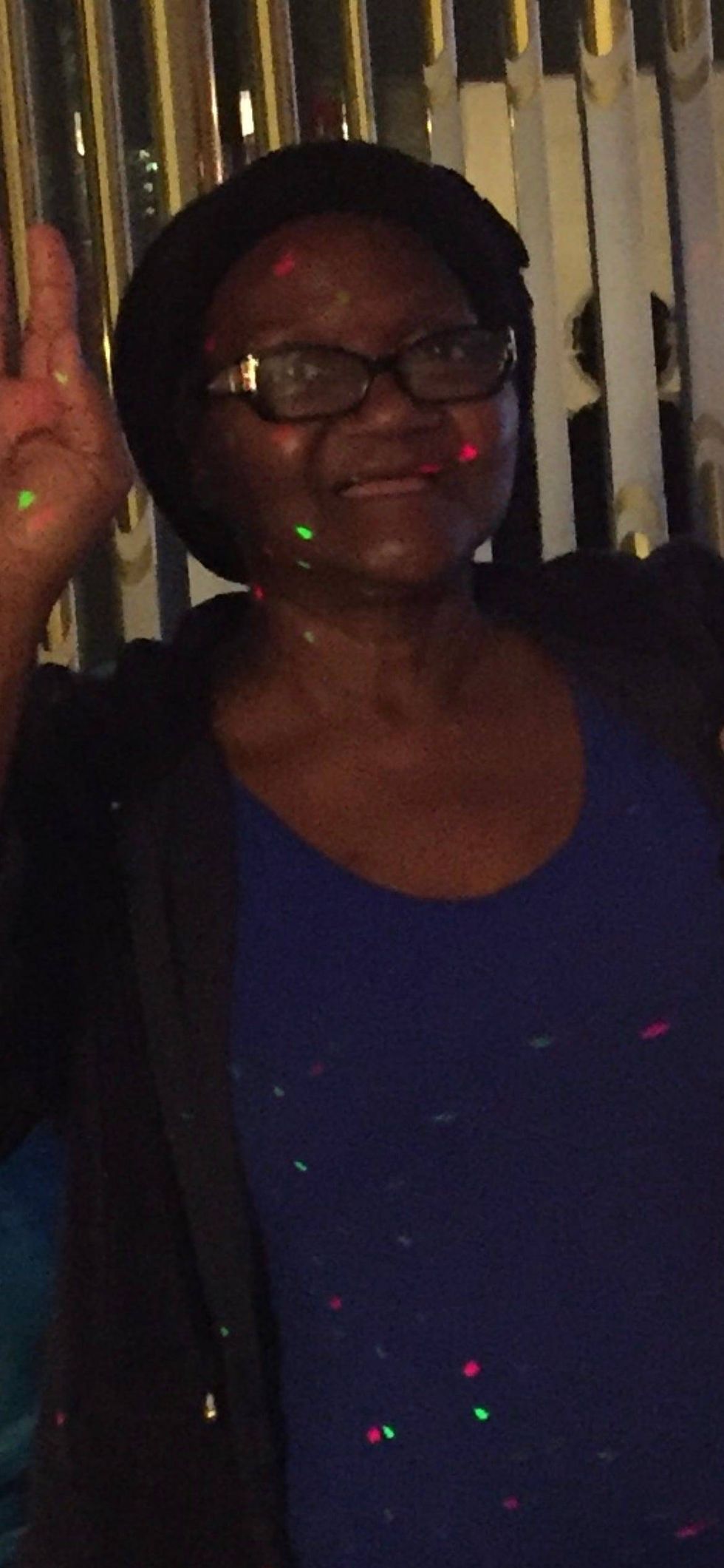 Black woman in her 70s smiling and wearing glasses