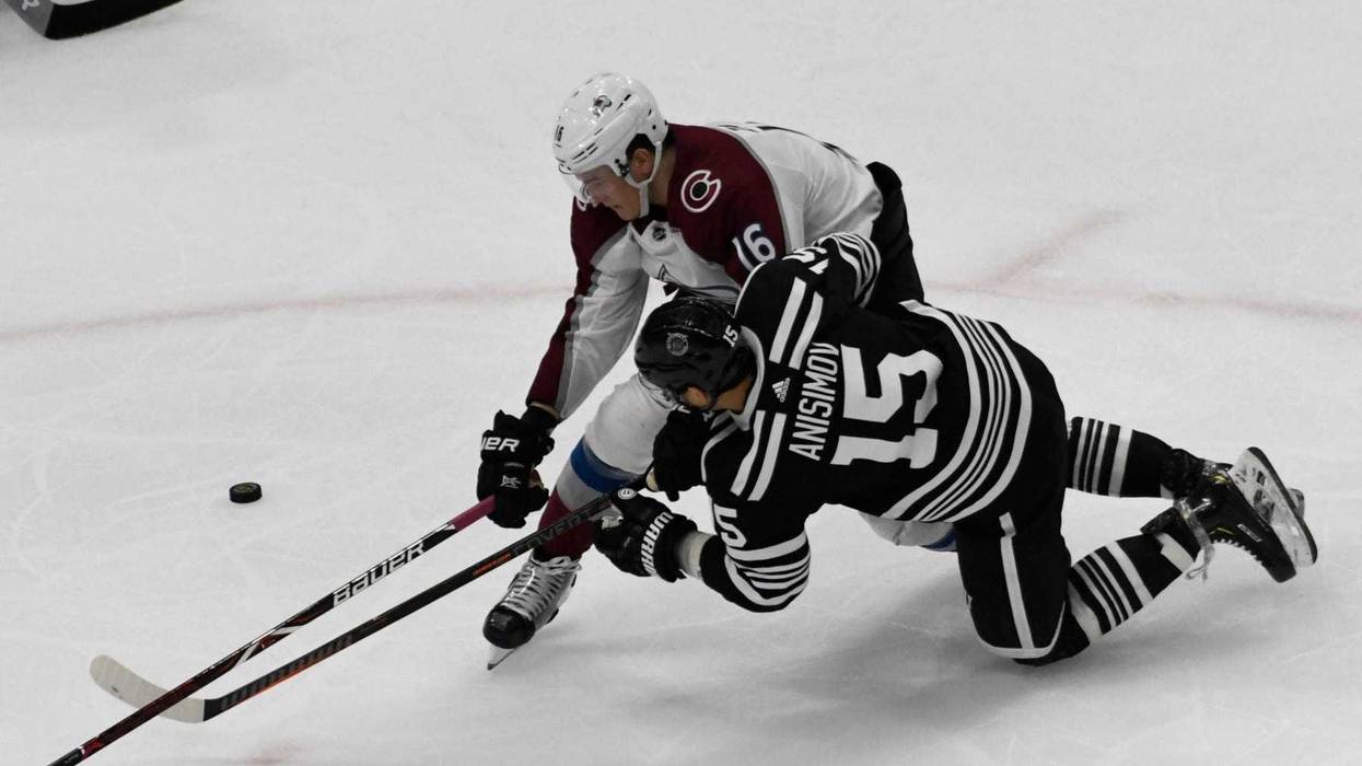 Blackhawks center Artem Anisimov (15) and Avalanche defenseman Nikita Zadorov (16) fight for the puck.
