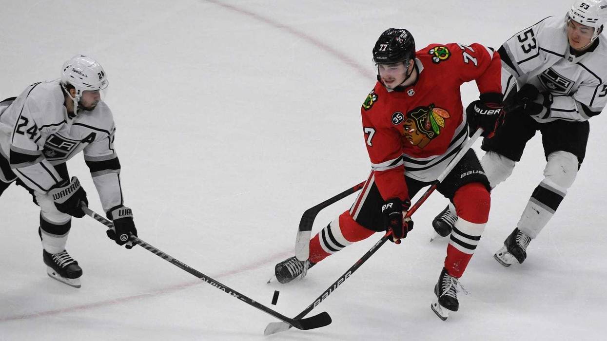 Blackhawks center Kirby Dach (77) fights for the puck with Kings center Phillip Danault (24) and defenseman Jordan Spence (53).