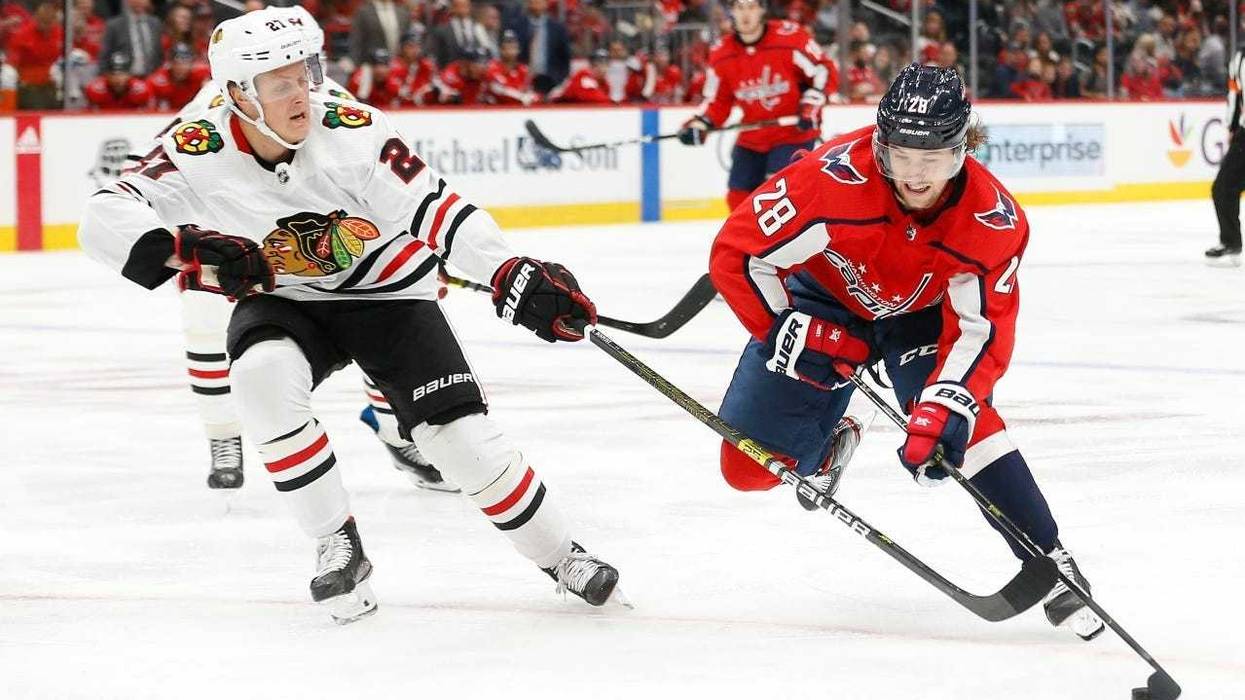Blackhawks defenseman Adam Boqvist, left, defends against Capitals winger Brendan Leipsic (28).