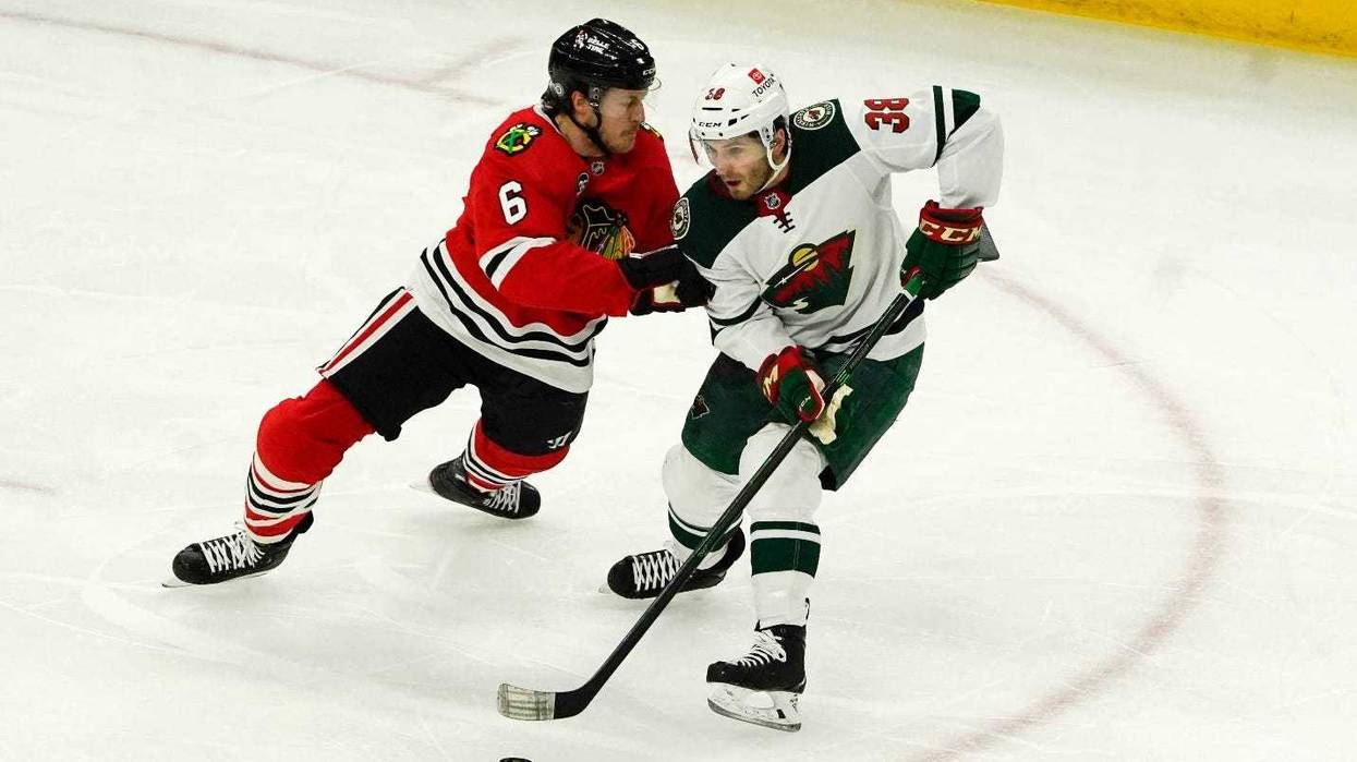 Blackhawks defenseman Jake McCabe (6) defends Wild right wing Ryan Hartman (38)).