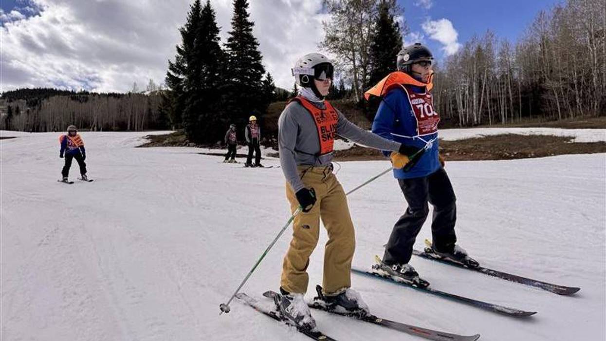 Blind Veteran Zach Tidwell skis with the assist of his instructor at the 40th National Disabled Veterans Winter Sports Clinic in Snowmass, Co.