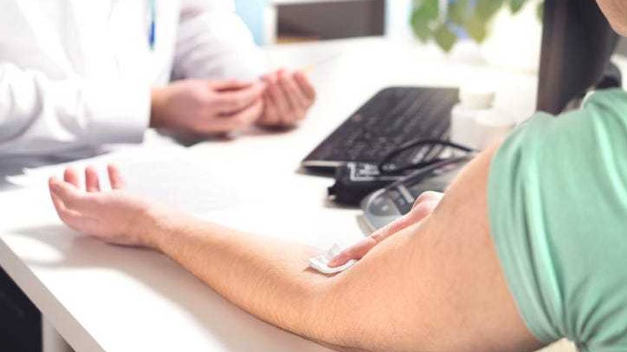 Blood test, sample or donation concept. Doctor with patient in hospital office, emergency room or laboratory. Person holding swab on arm after injection