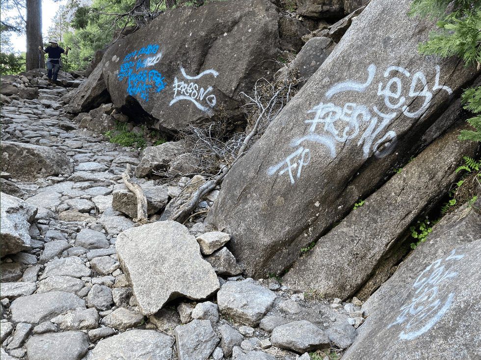 Blue and white graffiti on the Yosemite Falls Trail.