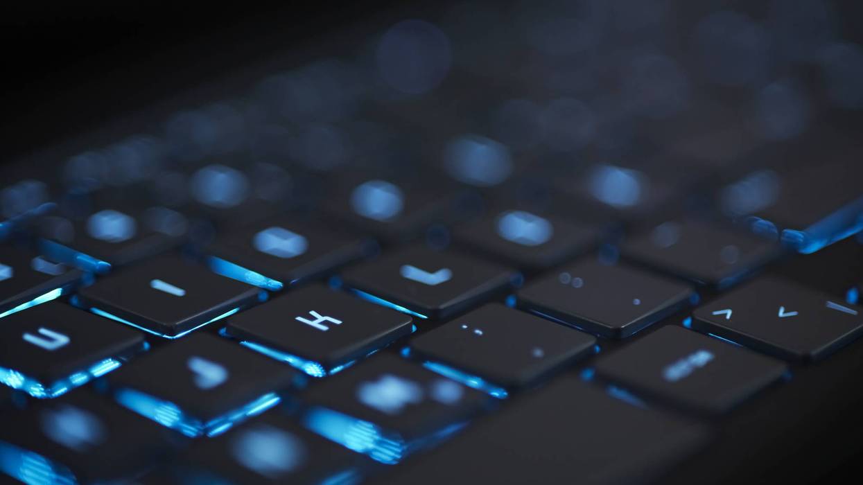 blue glowing modern keyboard with blurred bokeh background