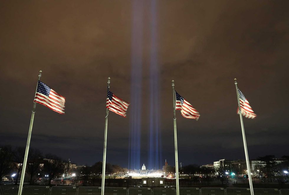 Blue lights are beamed into the sky over the "Field of Flags" on the National Mall as the U.S Capitol Building is prepared for the inauguration ceremonies for President-elect Joe Biden on January 18, 2021 in Washington, DC.