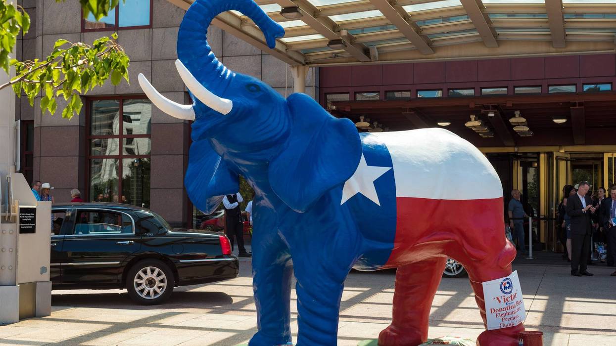 **Blue Republican elephant statue, Texas flag design, donation box, outside building.**