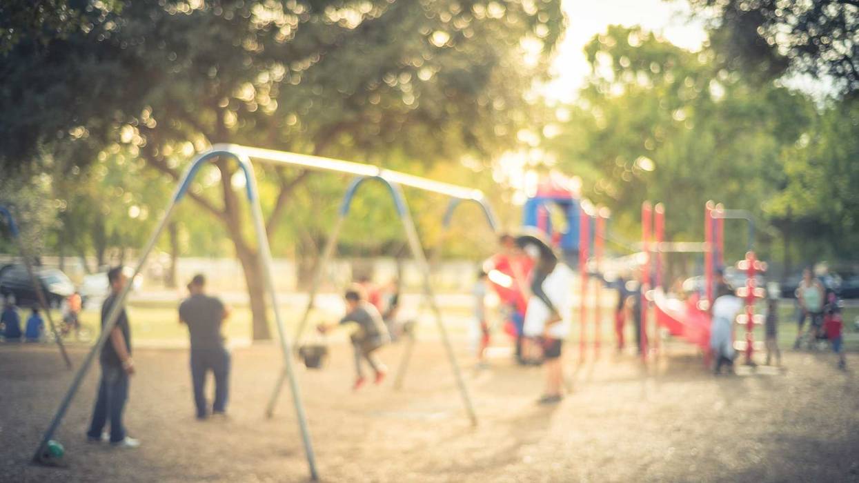 Blurred motion kids swing back and forth at public playground