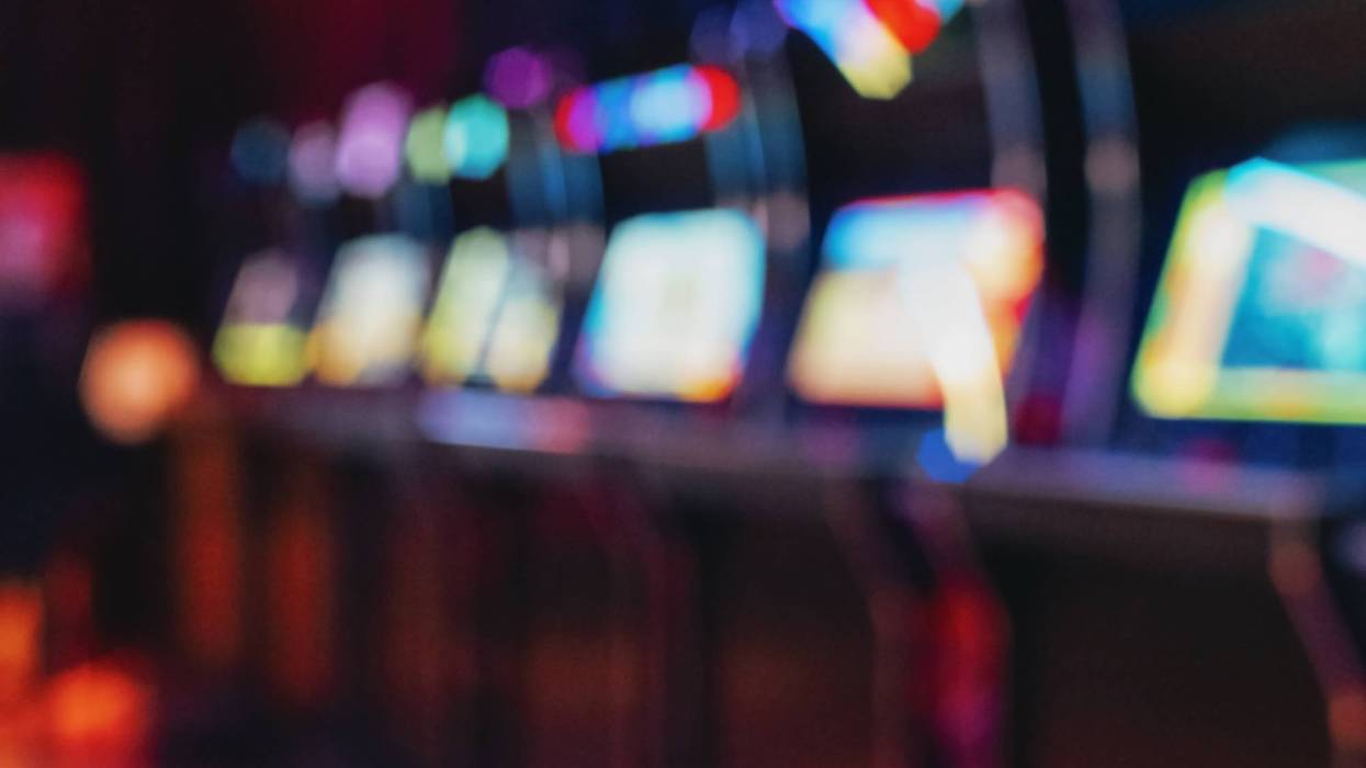 Blurred row of vintage arcade machines with colorful illuminated screens, background