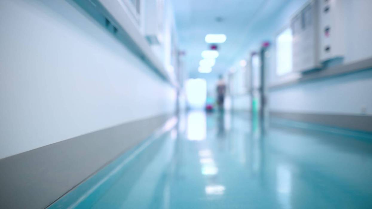 Blurry hospital hallway with blue floors and white walls