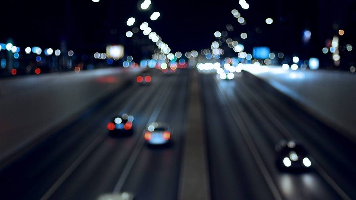 Blury night city traffic background, dark road and blurred cars in motion