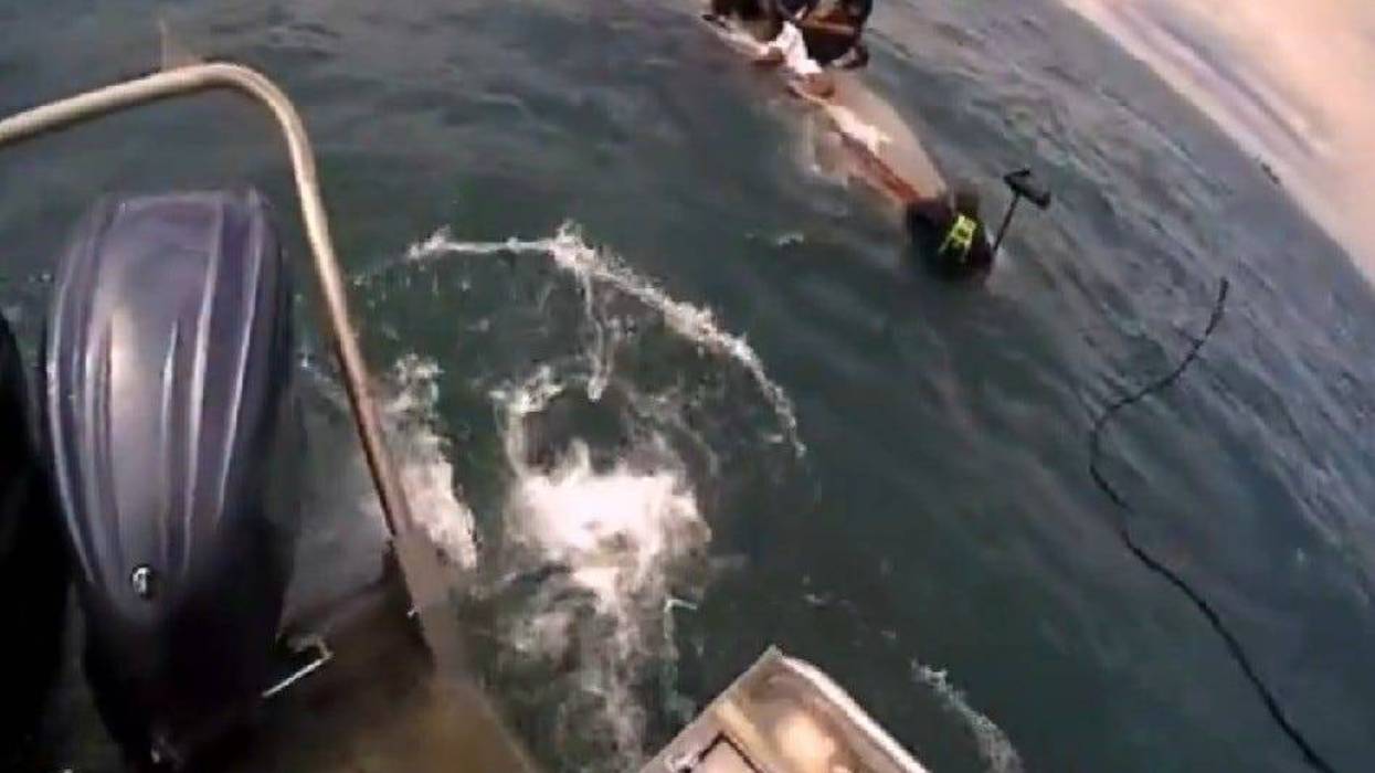 Boaters on top of capsized boat in Lake St. Clair