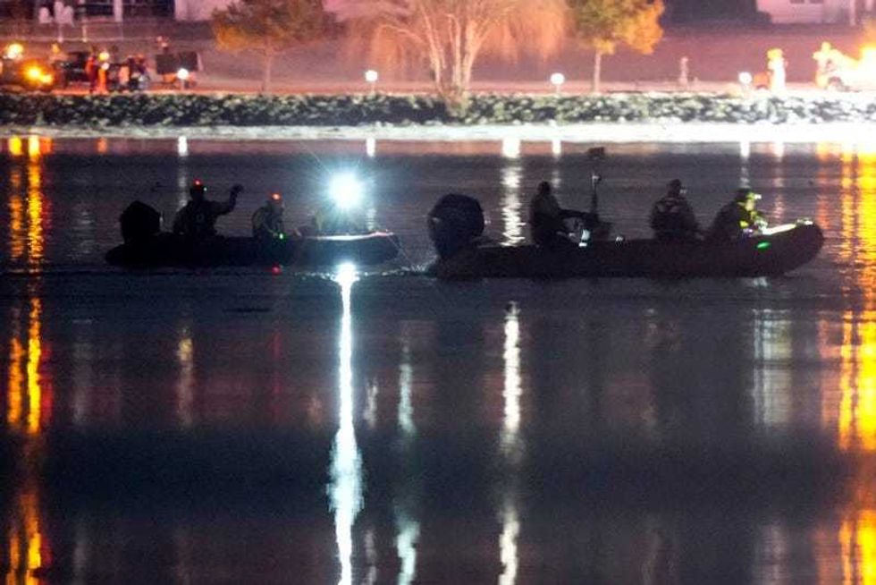 Boats work the scene in the Potomac River near Ronald Reagan Washington National Airport, Thursday, Jan. 30, 2025, in Arlington, Va