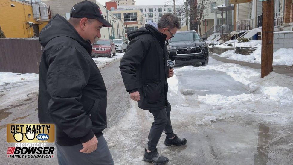 Bob Bastone shows Marty Griffin the icy problem on Carron Street in Pittsburgh.