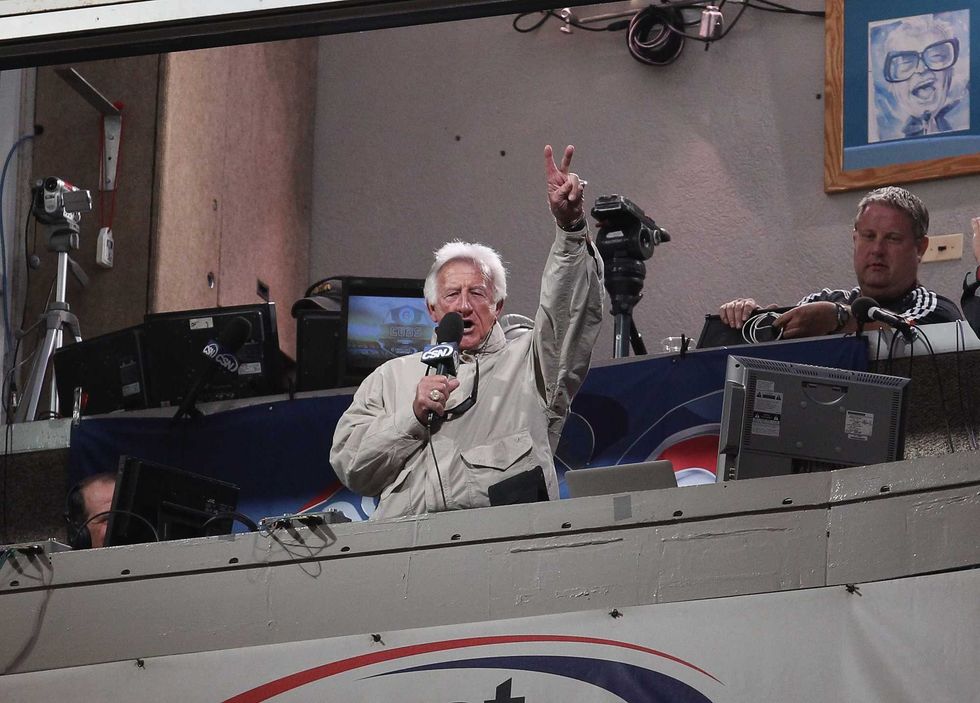 Bob Uecker sings "Take Me Out to the Ballgame" during the 7th inning stretch of a game between the Brewers and the Chicago Cubs at Wrigley Field on June 14, 2011 in Chicago, Illinois.
