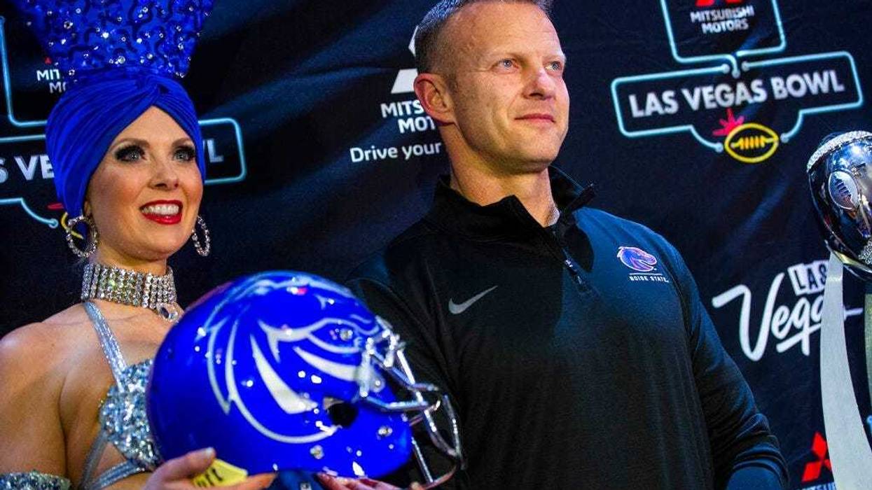 Boise State head coach Bryan Harsin poses alongside showgirl Jennifer Autry ahead of the Las Vegas Bowl NCAA college football game in Las Vegas, Tuesday, Dec. 17, 2019.