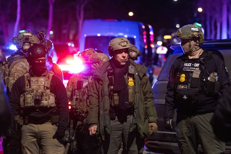 Border Patrol Chief Gregory Bovino and other federal agents guard a perimeter following a shooting incident as angry residents protest their presence in the city on January 14, 2026 in Minneapolis, Minnesota