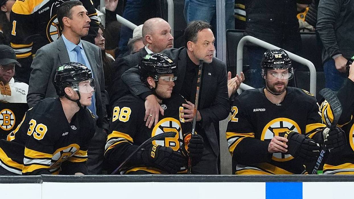 Boston Bruins coach Marco Sturm hugs David Pastrnak on the bench