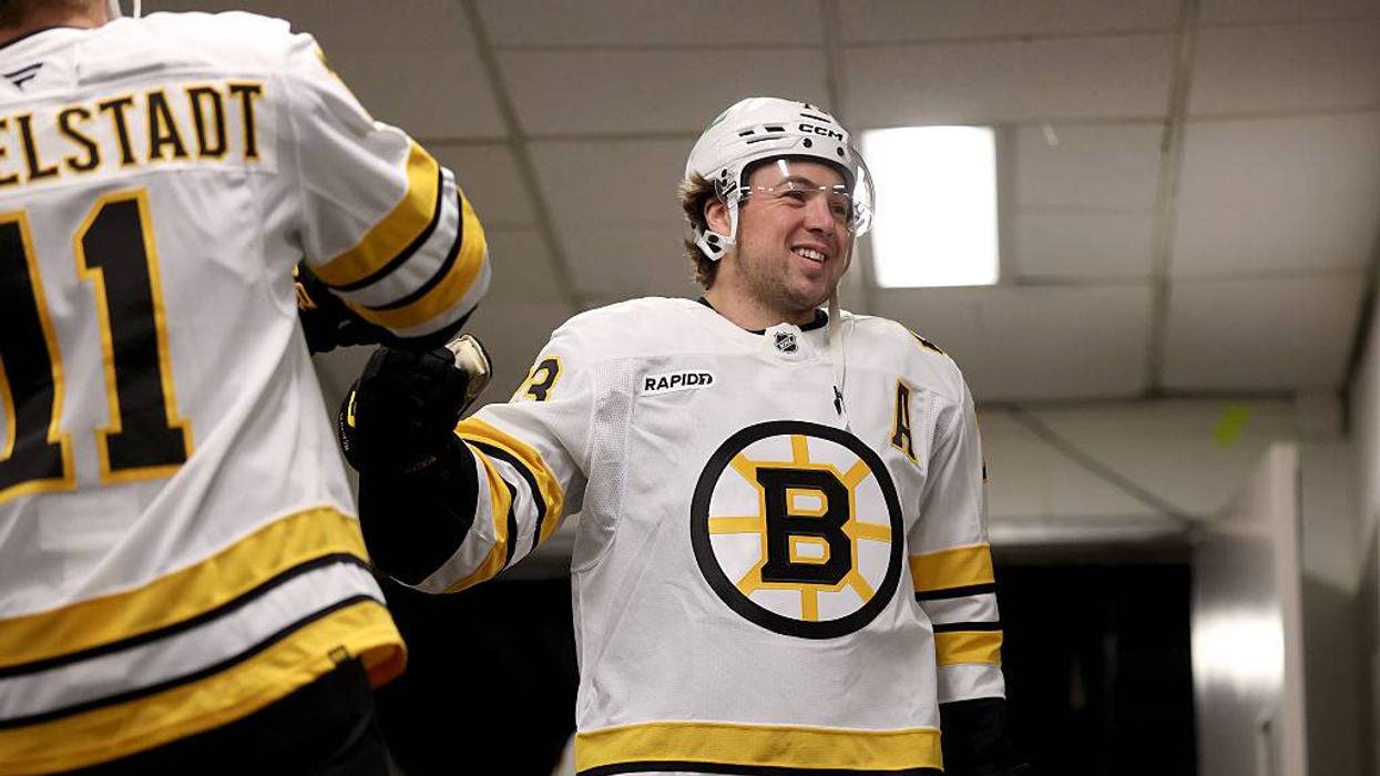 Boston Bruins defenseman Charlie McAvoy fist bumps Casey Mittelstadt
