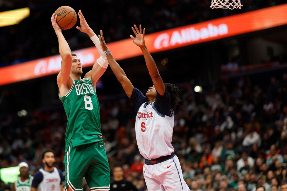 Boston Celtics center Kristaps Porzingis (8) shoots the ball as Washington Wizards guard Bub Carrington (8) defends in the second quarter at Capital One Arena.