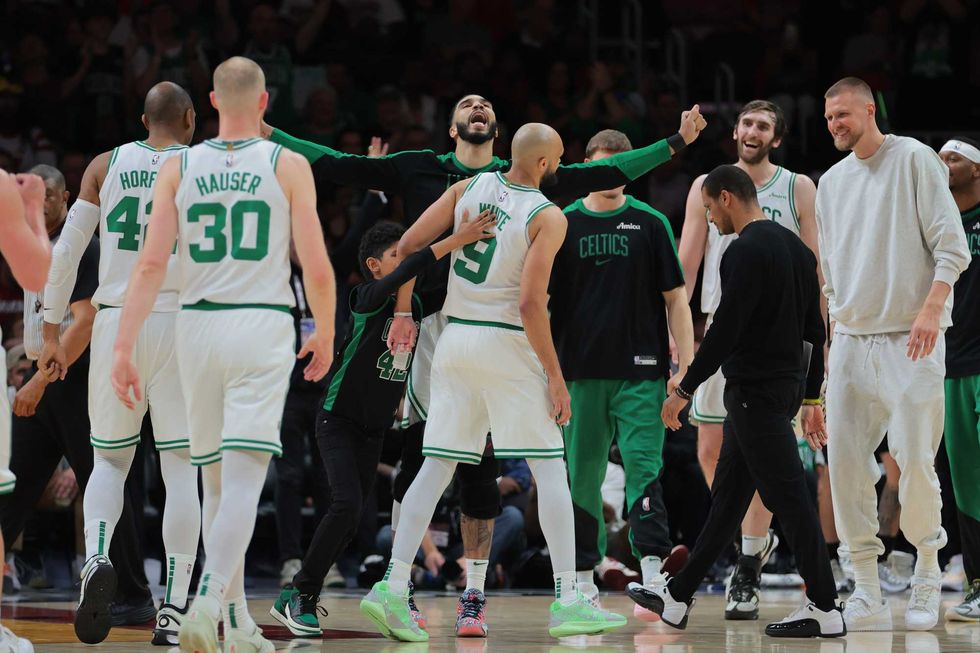 Boston Celtics forward Jayson Tatum (0) celebrates with guard Derrick White (9) against the Miami Heat during the fourth quarter at Kaseya Center.