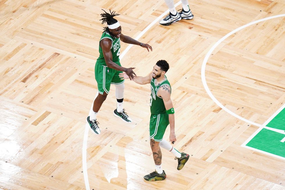 Boston Celtics forward Jayson Tatum (0) reacts with guard Jrue Holiday (4) in the fourth quarter against the Dallas Mavericks during game five of the 2024 NBA Finals at TD Garden.