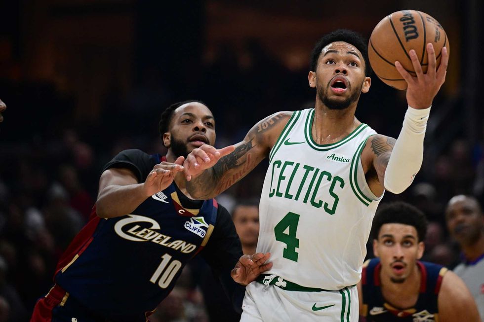 Boston Celtics guard Anfernee Simons (4) goes to the basket Cleveland Cavaliers guard Darius Garland (10) during the first half at Rocket Arena.