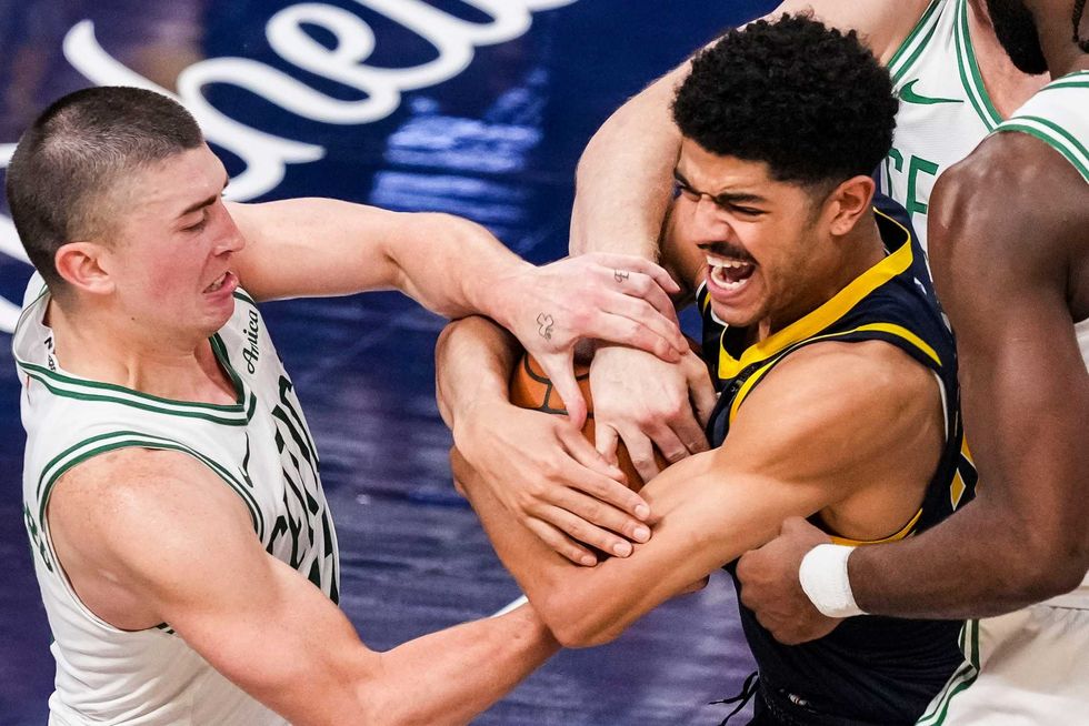 Boston Celtics guard Payton Pritchard (11) and Indiana Pacers guard Ben Sheppard (26) fight for the ball during a game at Gainbridge Fieldhouse.