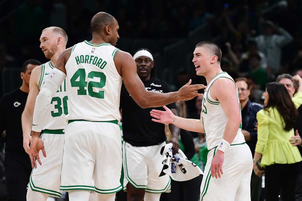 Boston Celtics guard Payton Pritchard (11) reacts with center Al Horford (42) after making a three point basket during the second half against the Orlando Magic at TD Garden.
