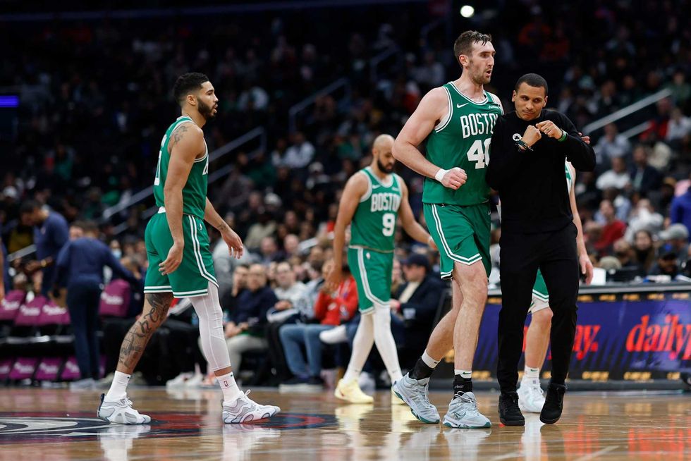 Boston Celtics head coach Joe Mazzulla (R) celebrates with Celtics center Luke Kornet (40) after a called timeout against the Washington Wizards in the third quarter at Capital One Arena.