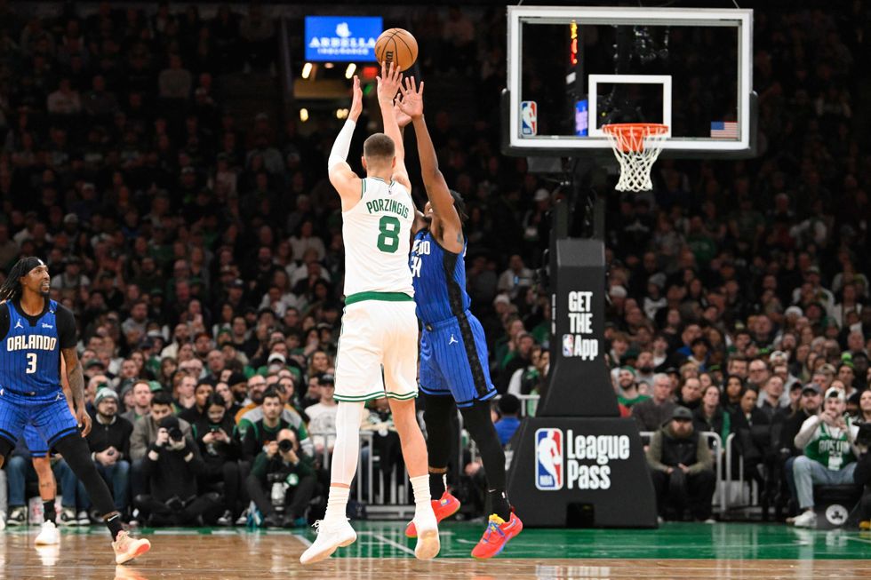 Boston, Massachusetts, USA; Boston Celtics center Kristaps Porzingis (8) shoots over Orlando Magic center Wendell Carter Jr. (34) during the first half at TD Garden.