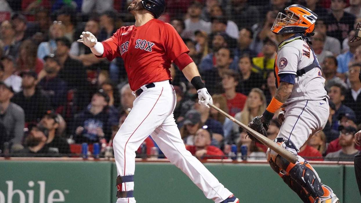Boston Red Sox left fielder J.D. Martinez (28) hits a sacrifice fly to bring in a run against the Houston Astros in the eighth inning at Fenway Park.