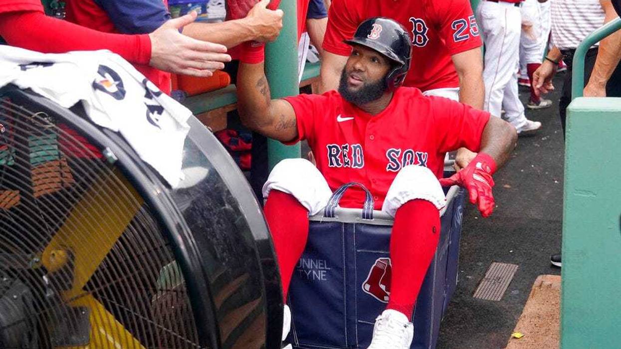 Boston Red Sox's Danny Santana celebrates his three-run homer against the Kansas City Royals with a dugout ride in a laundry cart.